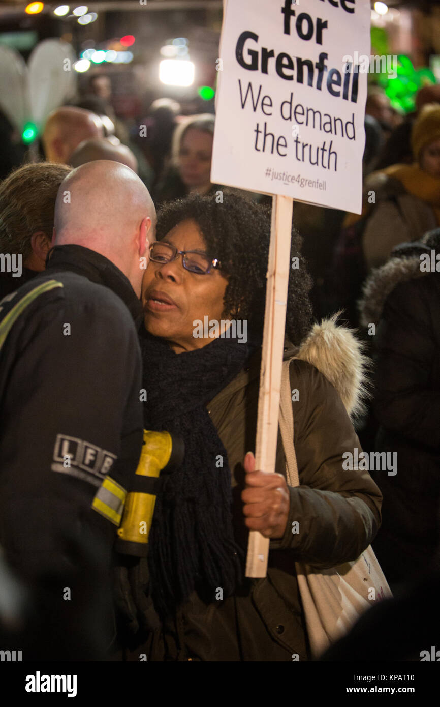 UK. London. North Kensington. Hundreds gather for the Grenfell silent walk held on the 14th of every month in solidarity and support for all those affected by the Grenfell Tower disaster. A woman thanks a member of North Kensington Fire Brigade who stood on Ladbroke Grove. December 14th 2017 Photo Credit: ÊZute Lightfoot/Alamy Live News Stock Photo