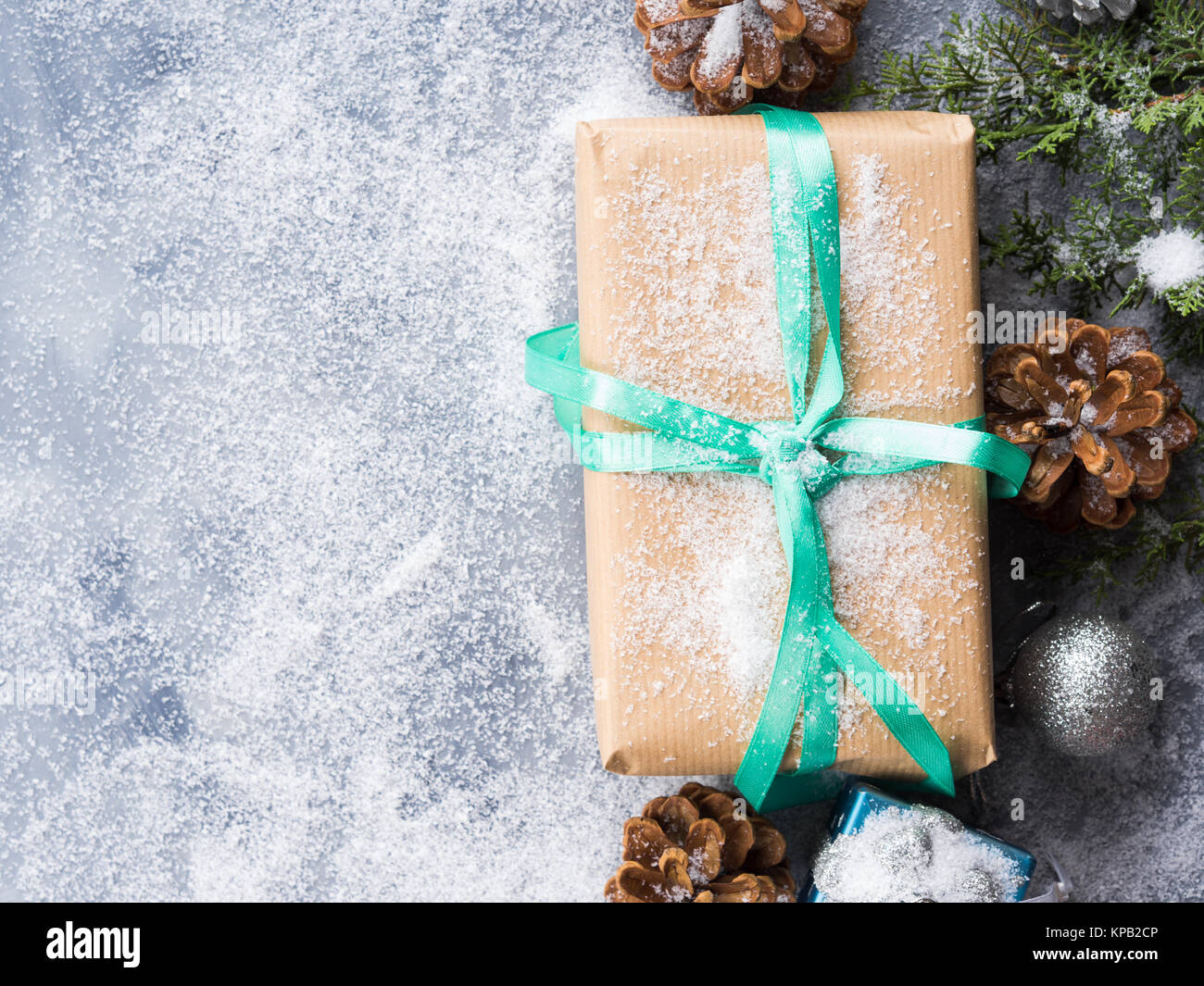 Christmas new year wrapped gift box with ribbon and snow. Pine cones ...