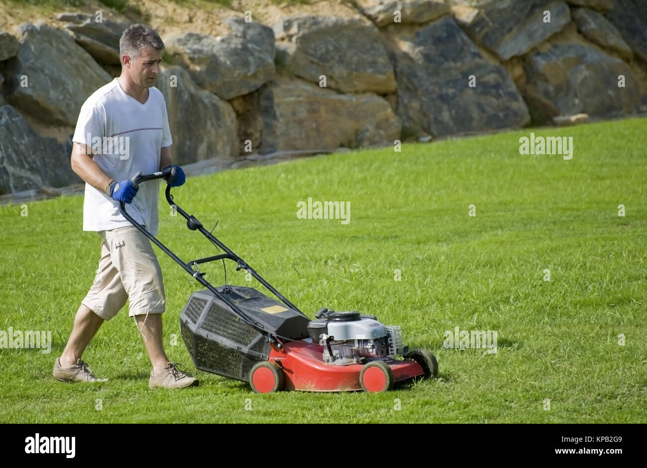 Model release, Mann beim Rasenmaehen - man with lawn-mower Stock Photo
