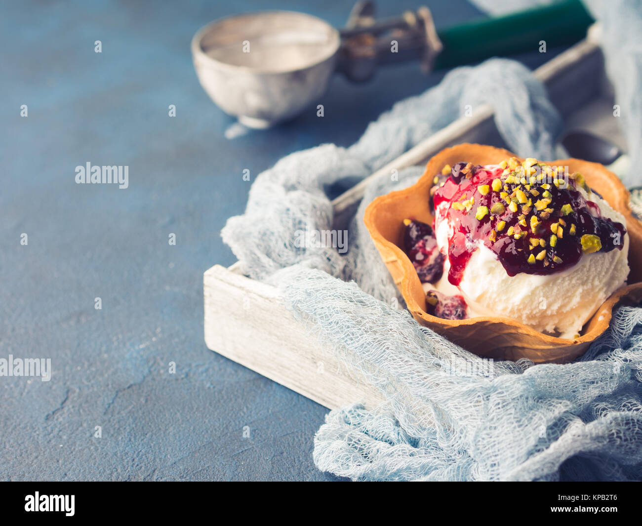 Vanilla home made ice cream scoops in waffle cup with berry sauce and ...