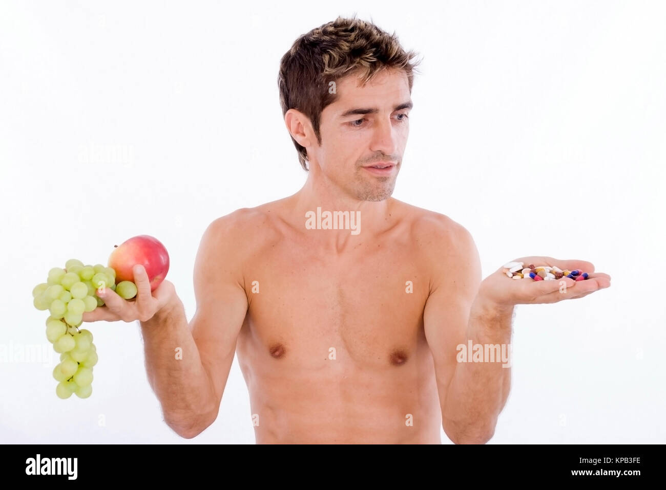 Model release, Mann mit Obst und Tabletten in den Haenden, Vitamine oder Nahrungsergaenzungss - man with fruits and tablets in hands Stock Photo