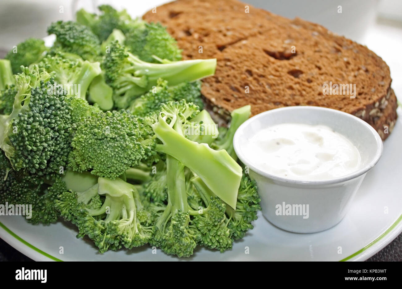 Nutritious rye bread sandwich with a side of fresh raw broccoli and a dipping sauce Stock Photo