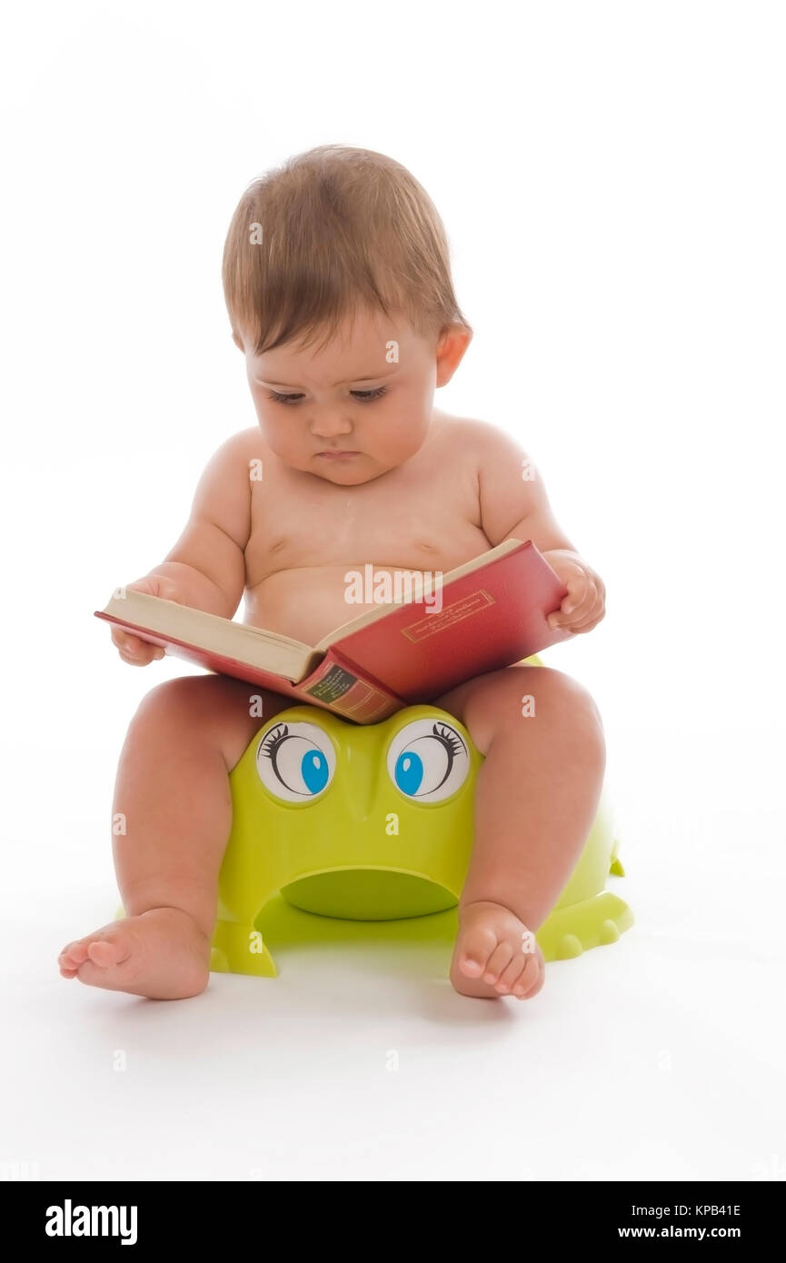 Model release, Kleinkind, 8 Monate, sitzt am Topf und liest ein Buch - little child sitting on potty Stock Photo