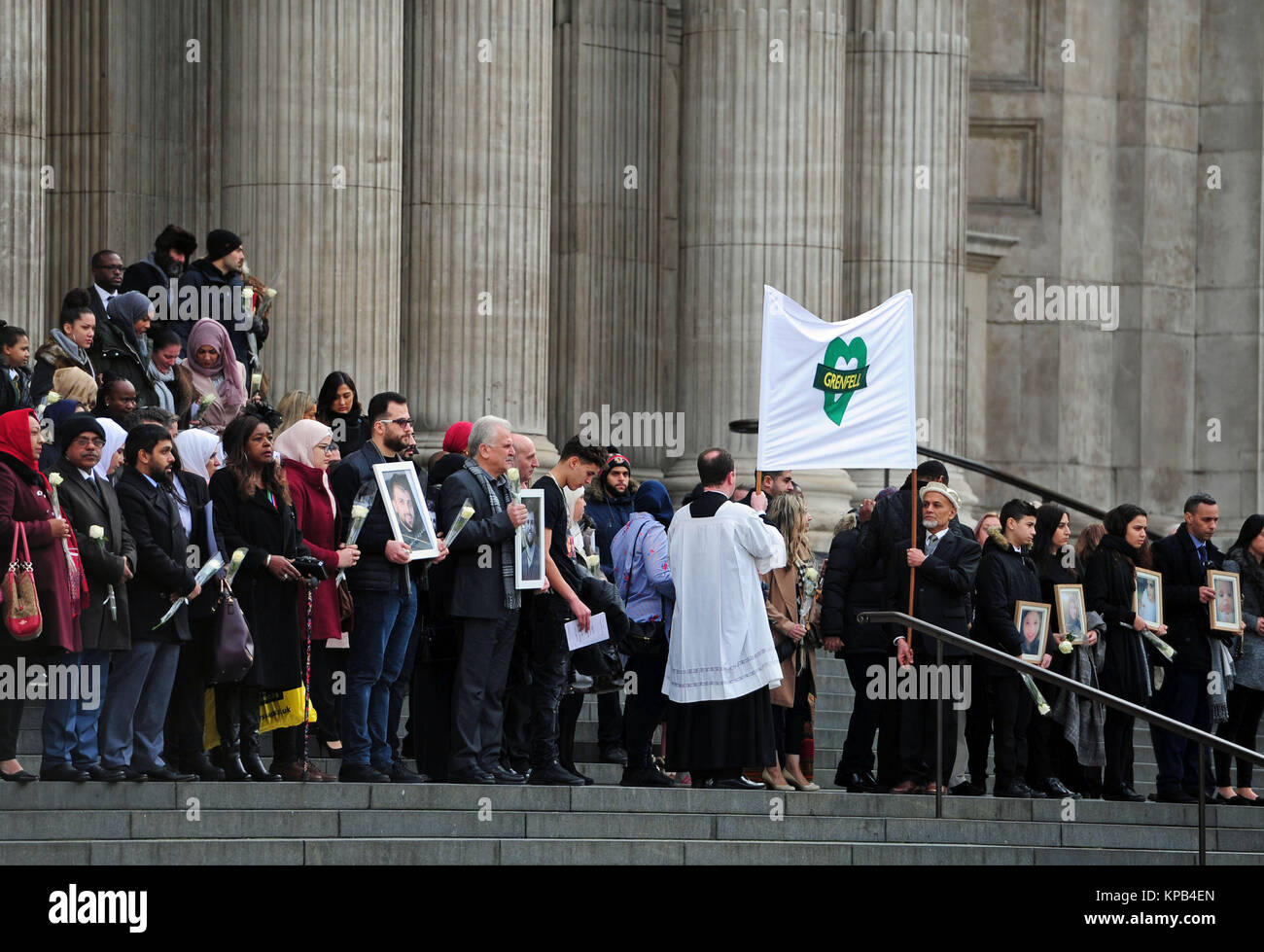 People hold photos and flowers as they leave after the Grenfell Tower National Memorial Service at St Paul's Cathedral in London, to mark the six month anniversary of the Grenfell Tower fire. Stock Photo