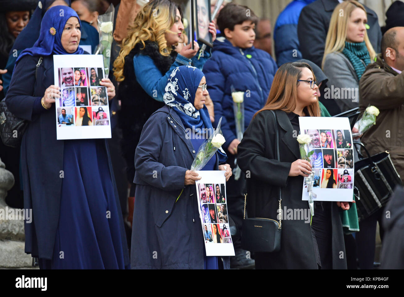 People hold photos and flowers as they leave after the Grenfell Tower National Memorial Service at St Paul's Cathedral in London, to mark the six month anniversary of the Grenfell Tower fire. Stock Photo