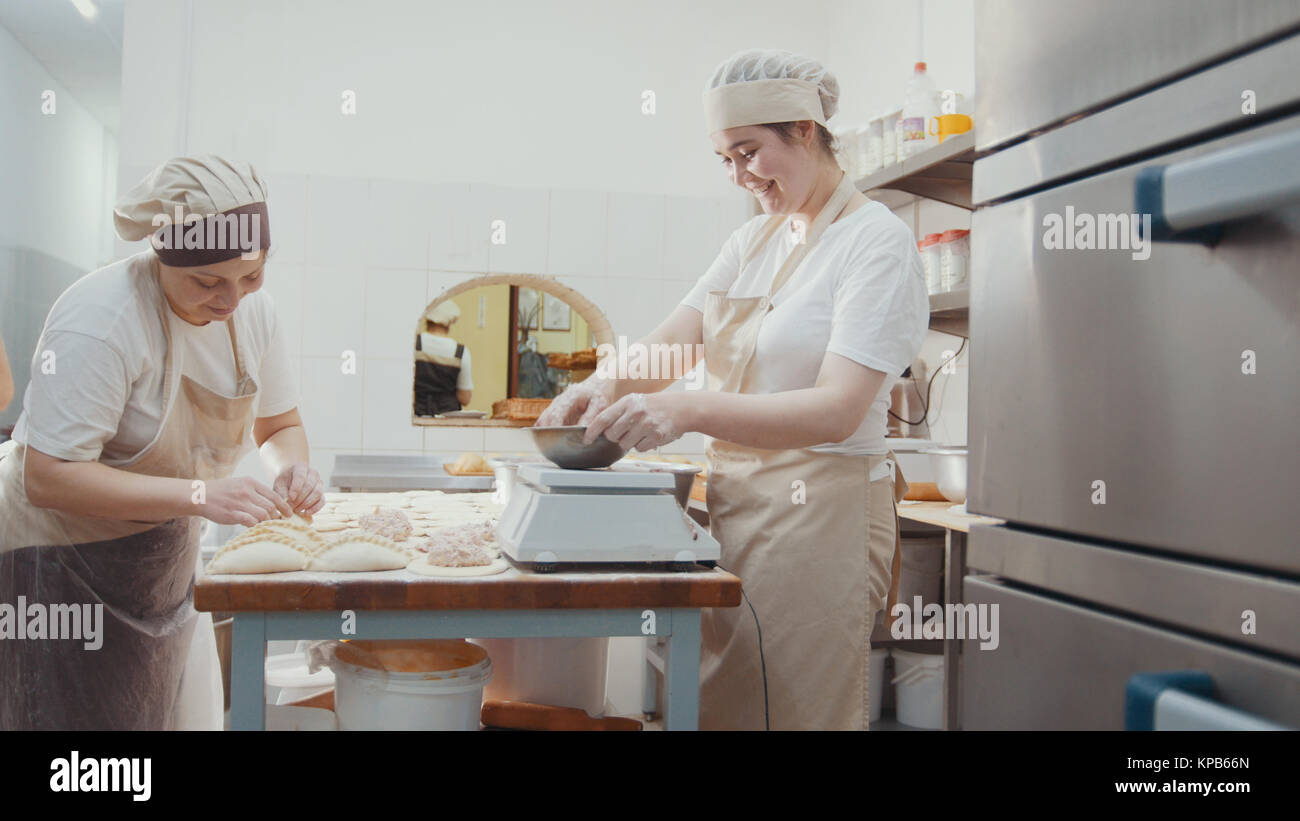 Cooks on the kitchen is making bakery products by hands, in full growth ...