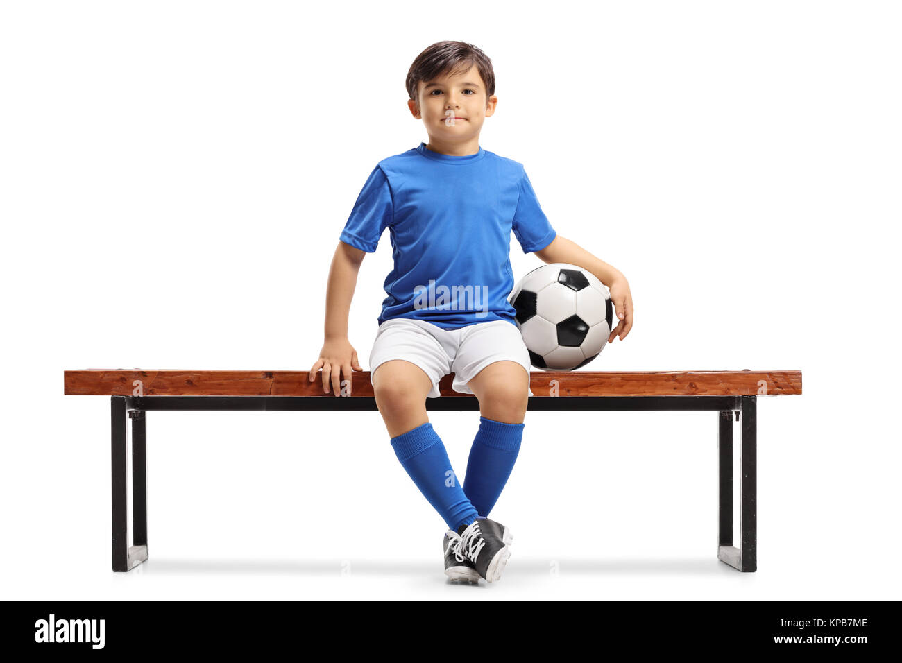 Little footballer sitting on a bench isolated on white background Stock Photo