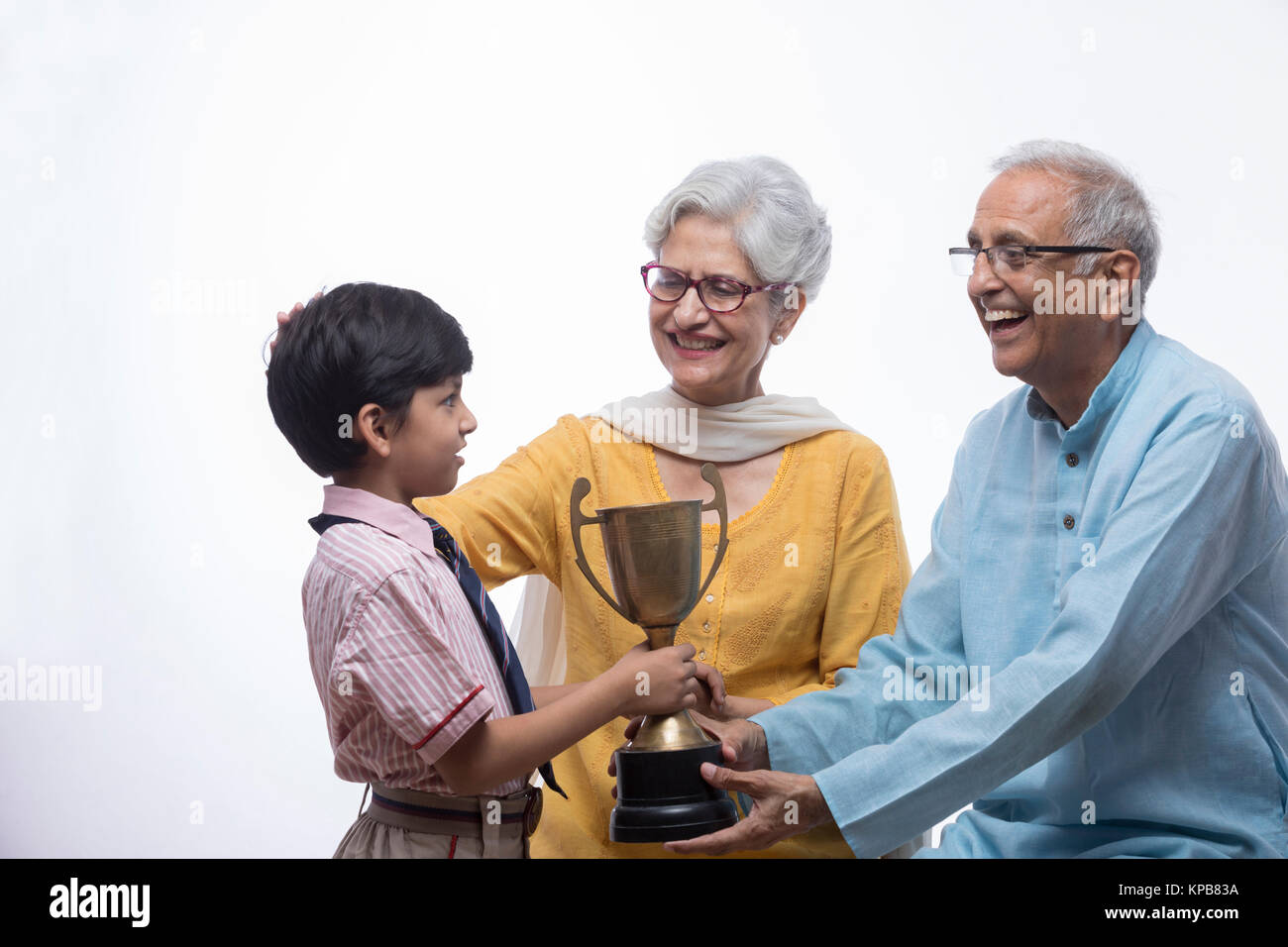 Boy showing trophy to grandparents Stock Photo