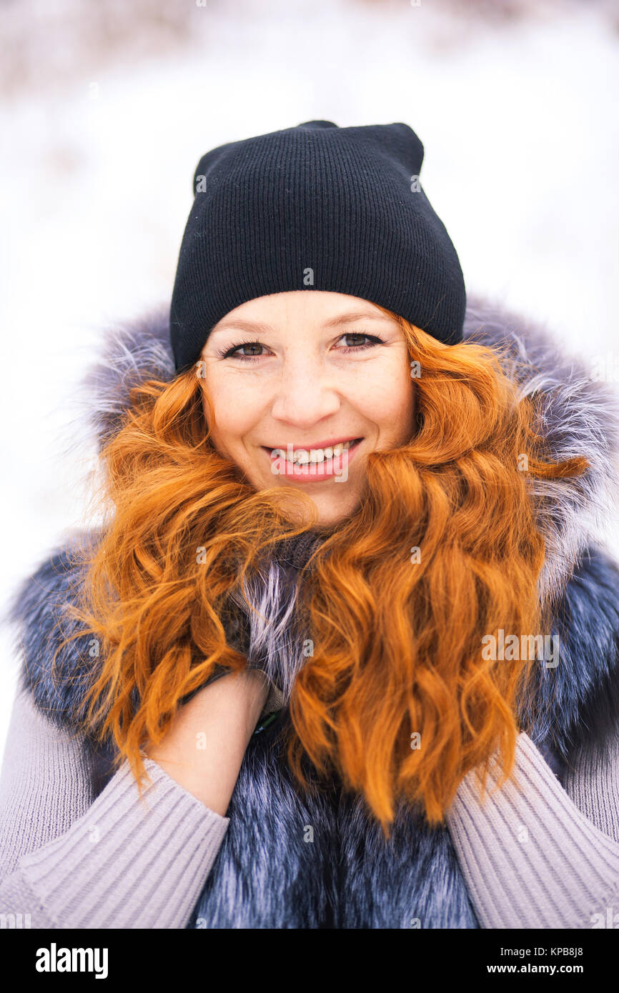 Portrait of beautiful young girl dressed in fur coat at winter ...