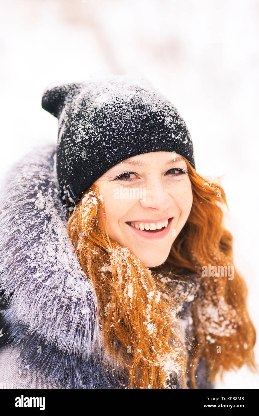 Portrait of beautiful young girl dressed in fur coat and black hat at ...