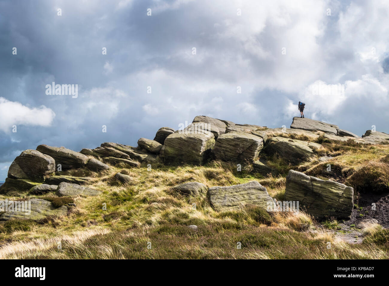 Person standing on the edge of a high rock, Edale Rocks, Kinder Scout, Derbyshire, Peak District, England, UK Stock Photo