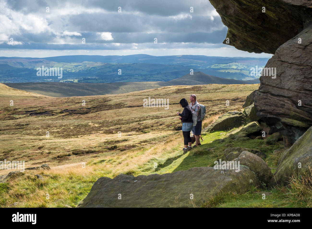 Walkers near Edale Rocks viewing the moorland scenery and the scenic countryside views, Kinder Scout, Derbyshire, Peak District, England, UK Stock Photo