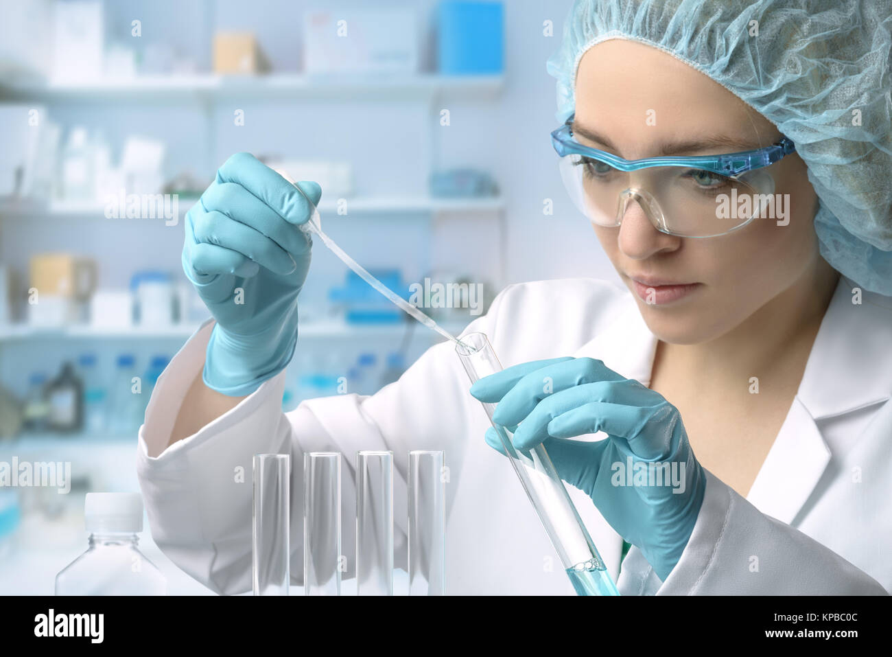 Young female tech or scientist loads liquid sample into test tube with