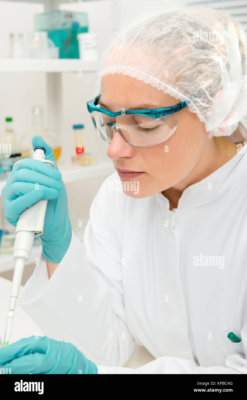 Young female tech or scientist works with automatic pipette Stock Photo