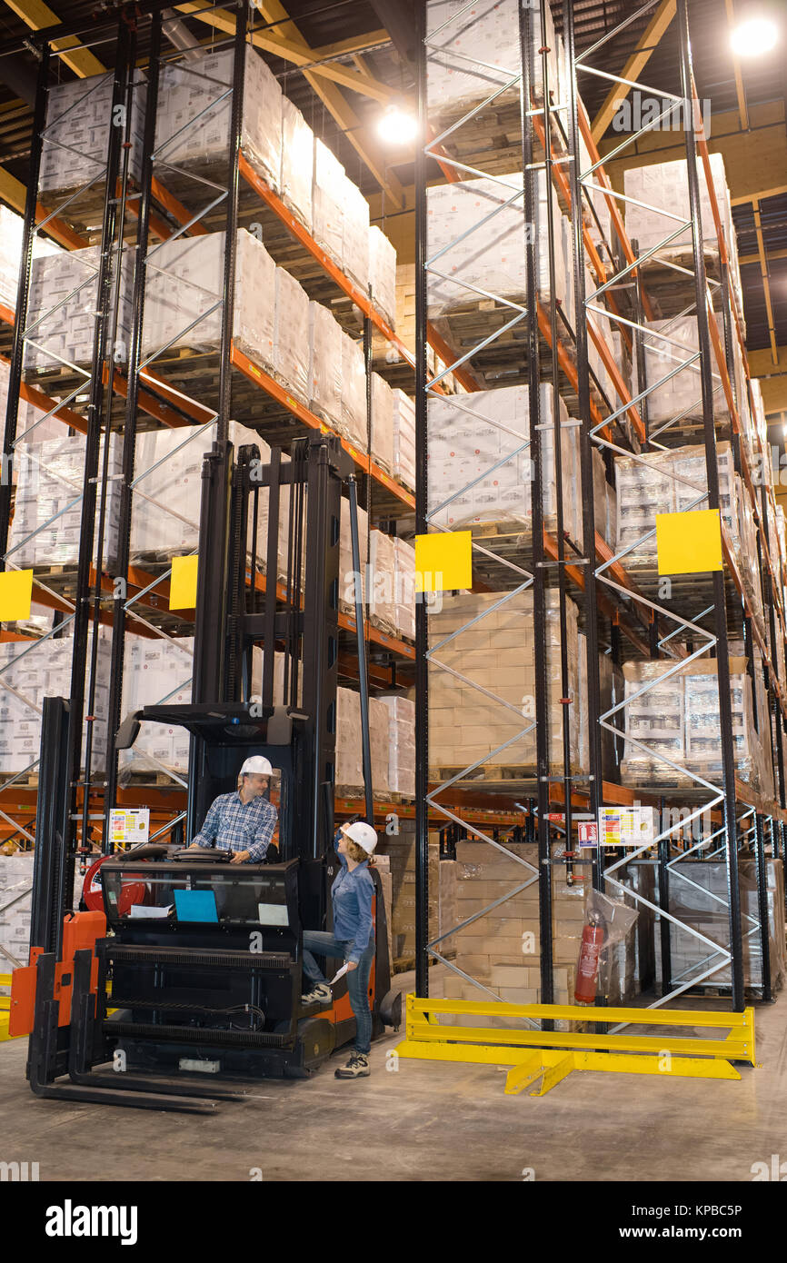 warehouse forklift stacker loader stacking cardboxes in storehouse