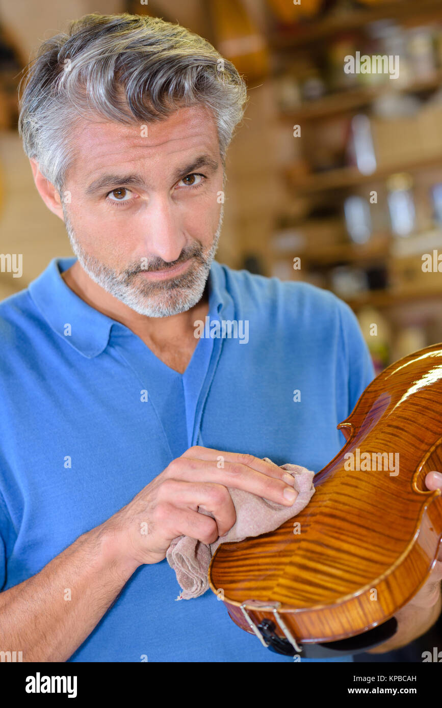 Luthier polishing violin Stock Photo Alamy