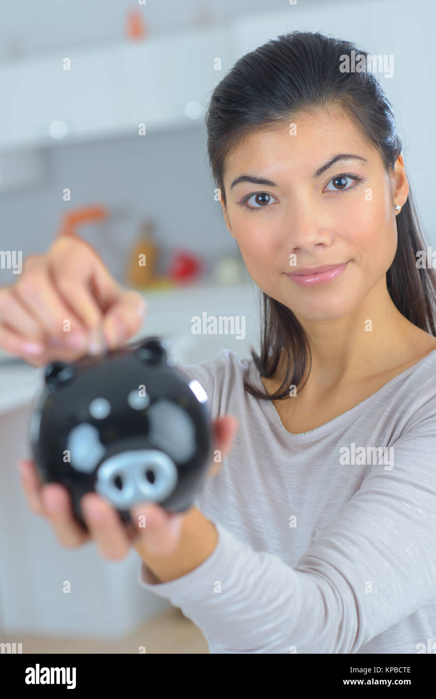 female hand putting coin into piggy bank closeup Stock Photo - Alamy