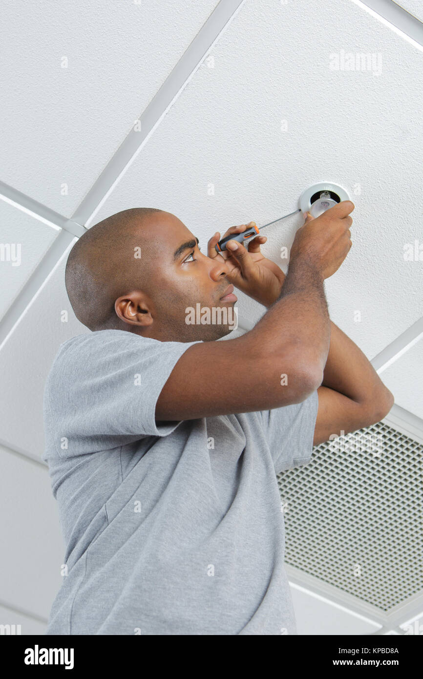 Man replacing spotlight bulb Stock Photo - Alamy
