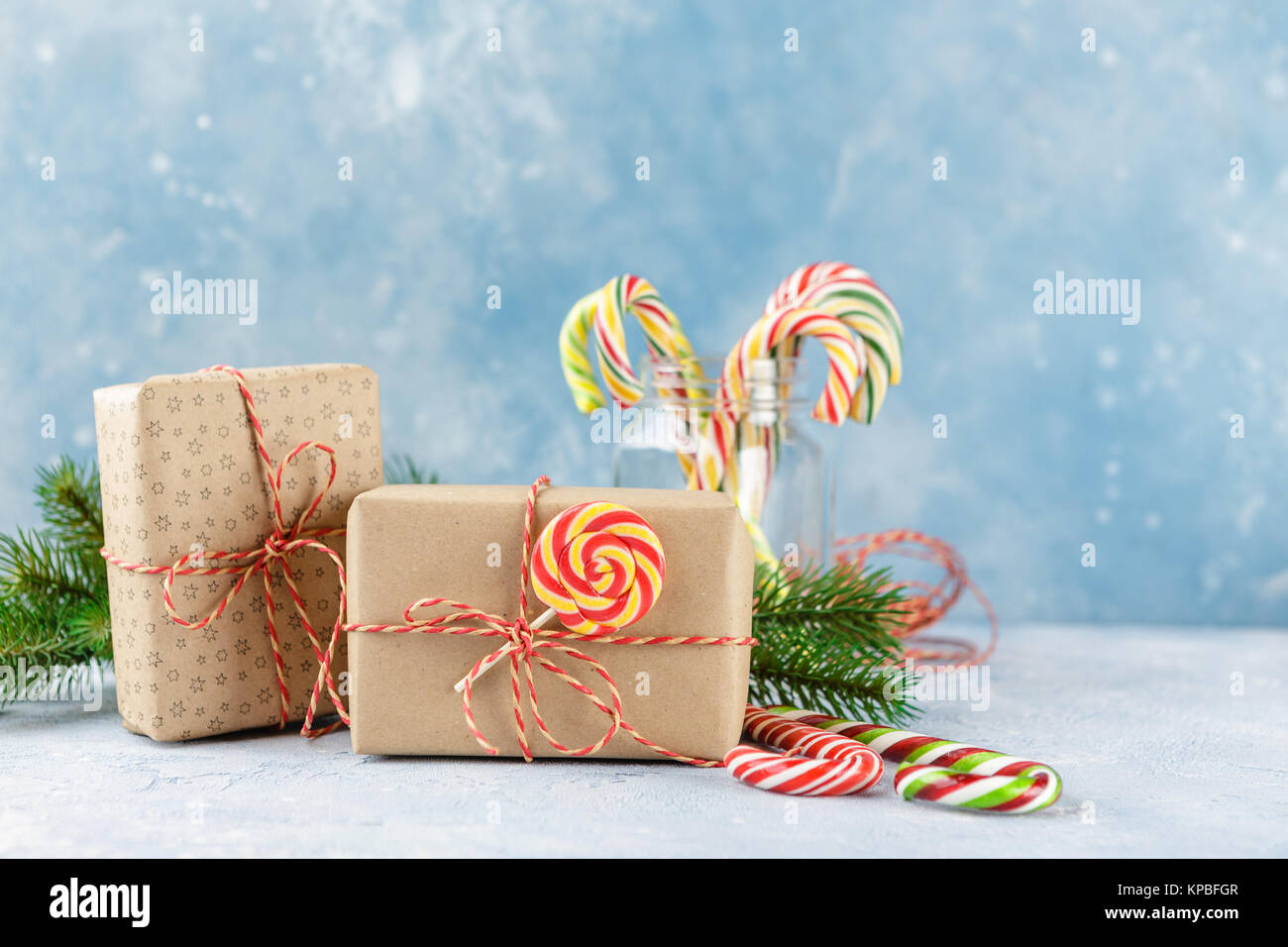 Gift boxes in kraft paper, candy canes and branch of Christmas trees on ...
