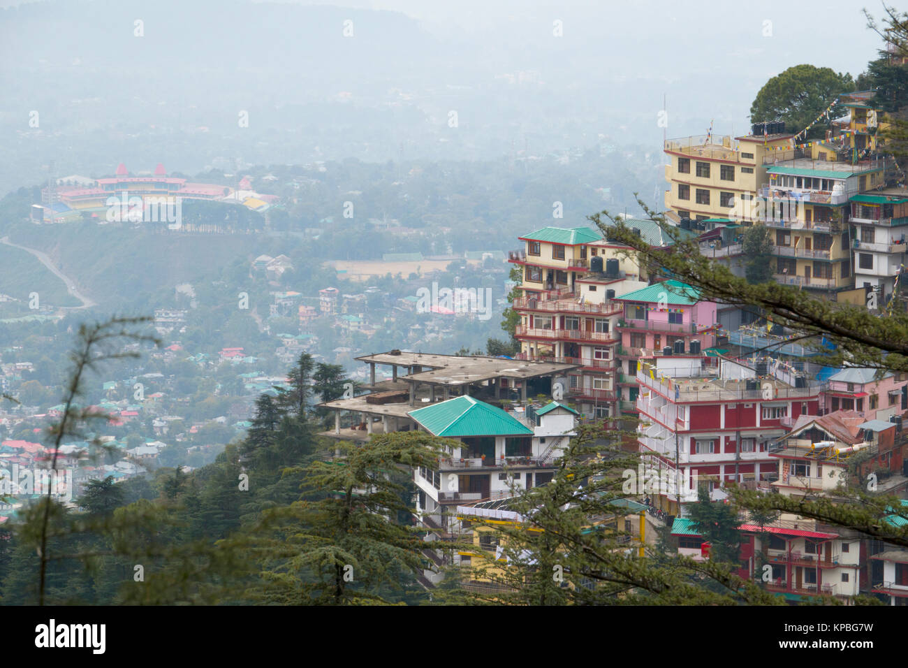 Hotels and apartments on hillside in Mcleod Ganj with Himachal Pradesh Cricket Association Stadium in Dharamshala below Stock Photo