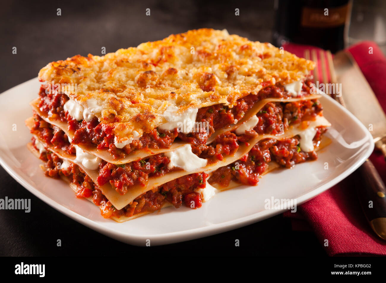 Absoluut Krimpen Toegepast Serving of spicy traditional Italian beef lasagne in a restaurant on a  modern white square plate with a red napkin, dark counter background Stock  Photo - Alamy