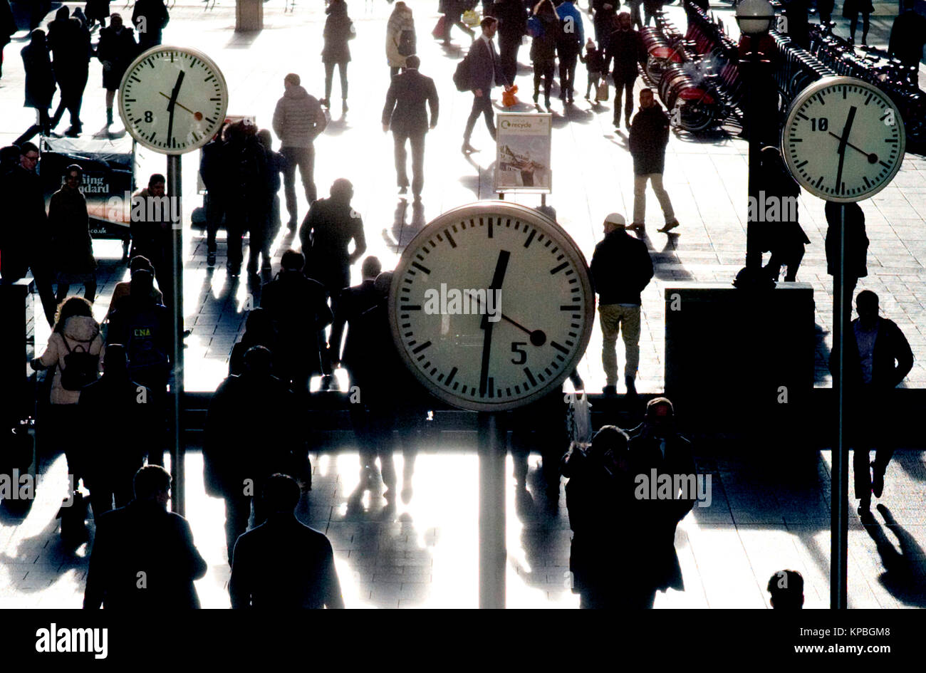 Pedestrians walk past decorative clocks in the Canary Wharf financial district in east London, Britain December 13, 2017 Stock Photo