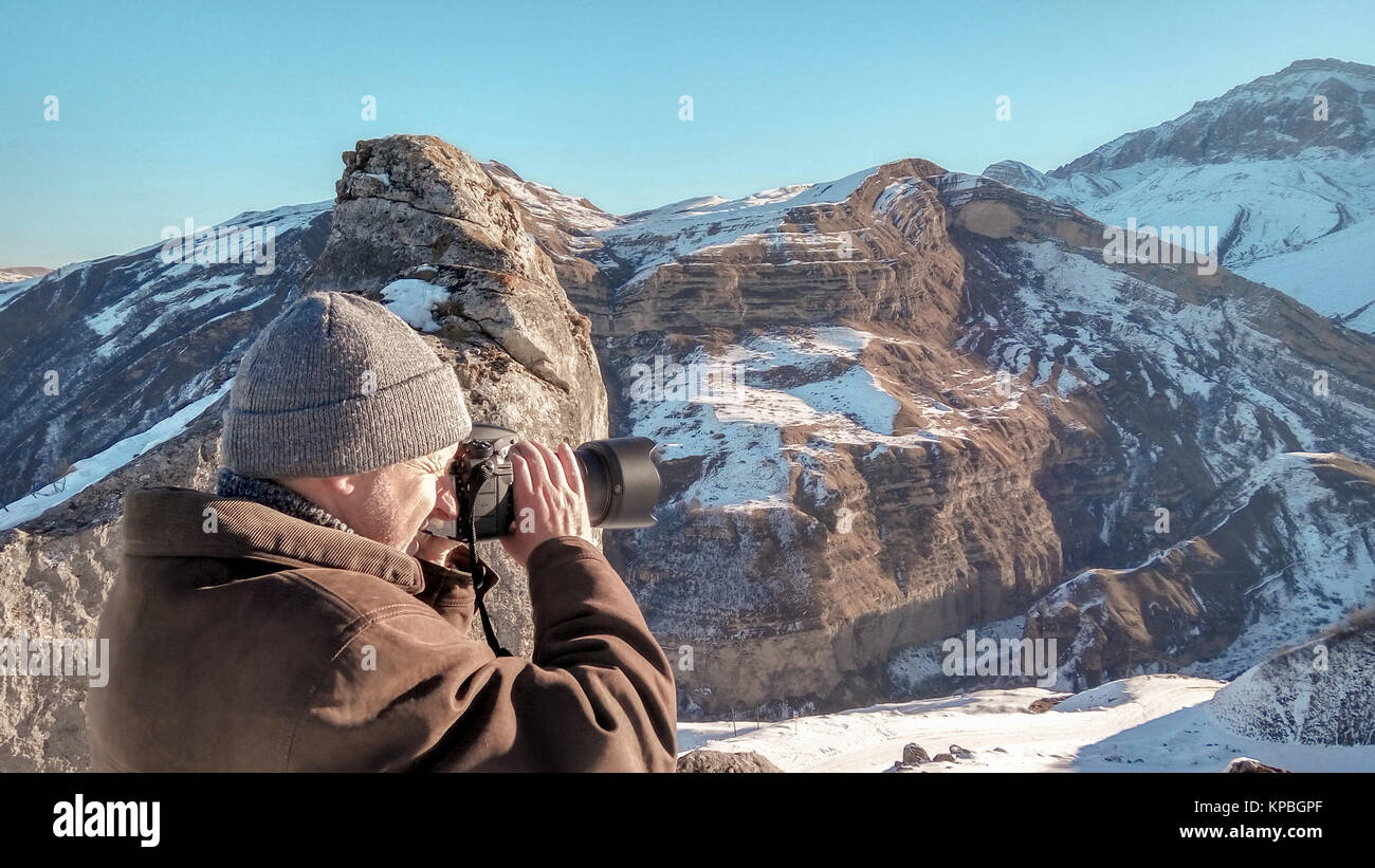 Nature photographer in winter mountains Stock Photo