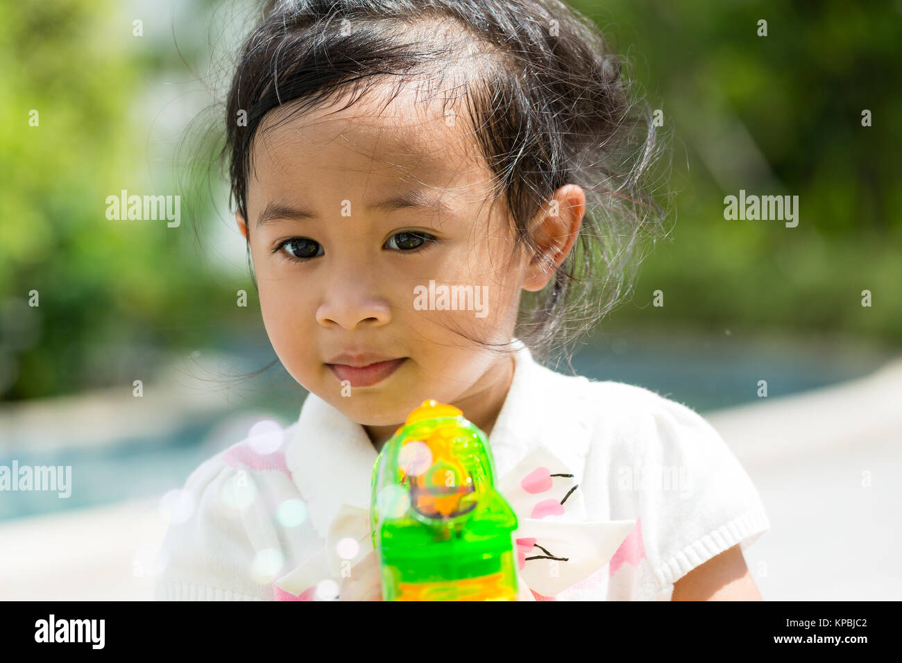 Little girl playing bubble blower at park Stock Photo - Alamy