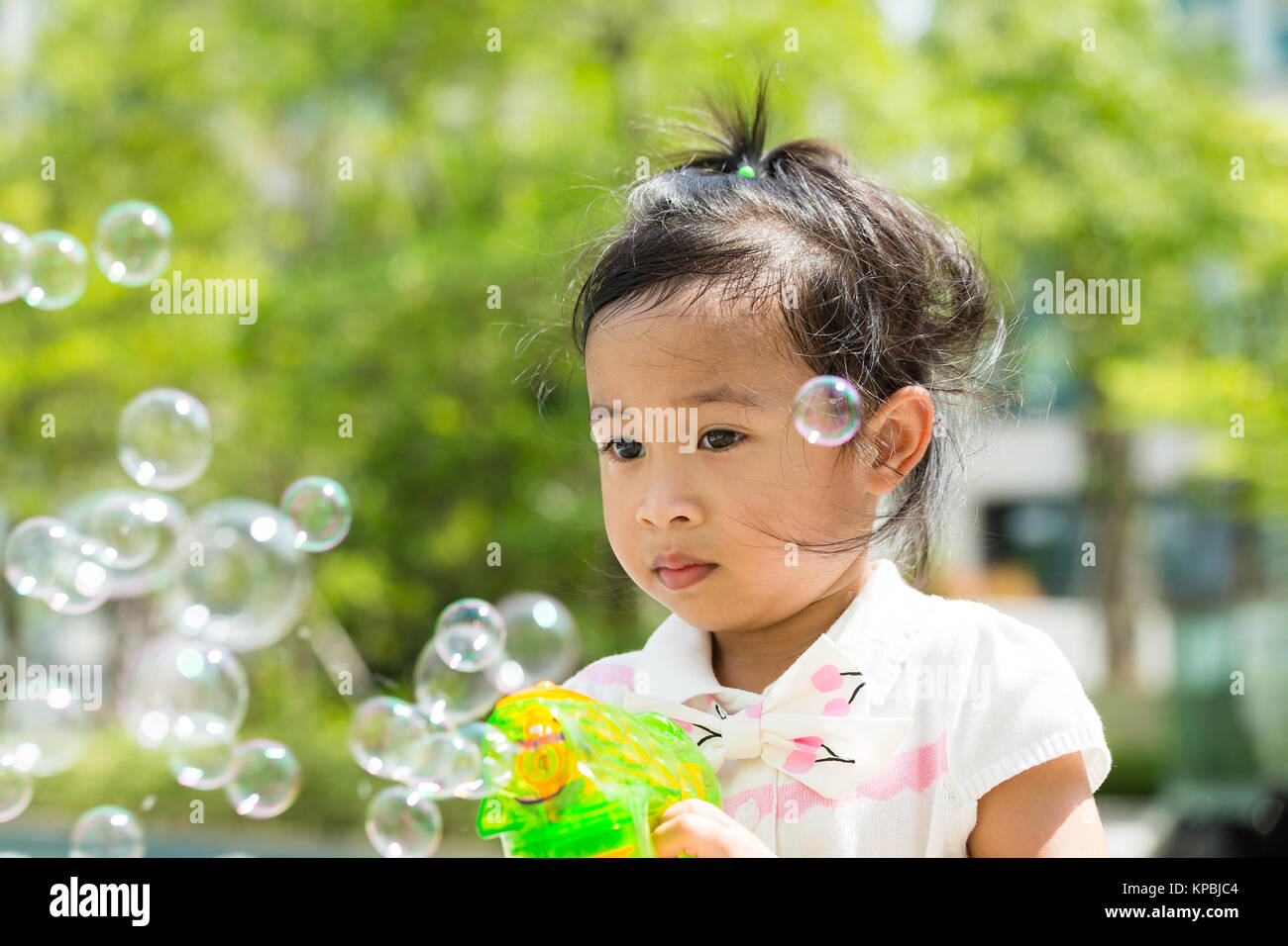 Lovely Girl play with bubble blower at outdoor Stock Photo - Alamy