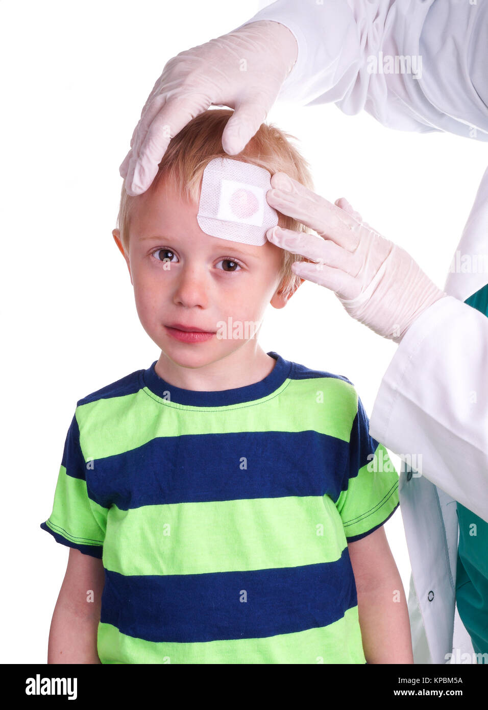 Boy has injury on forehead and gets help by the Doctor Stock Photo