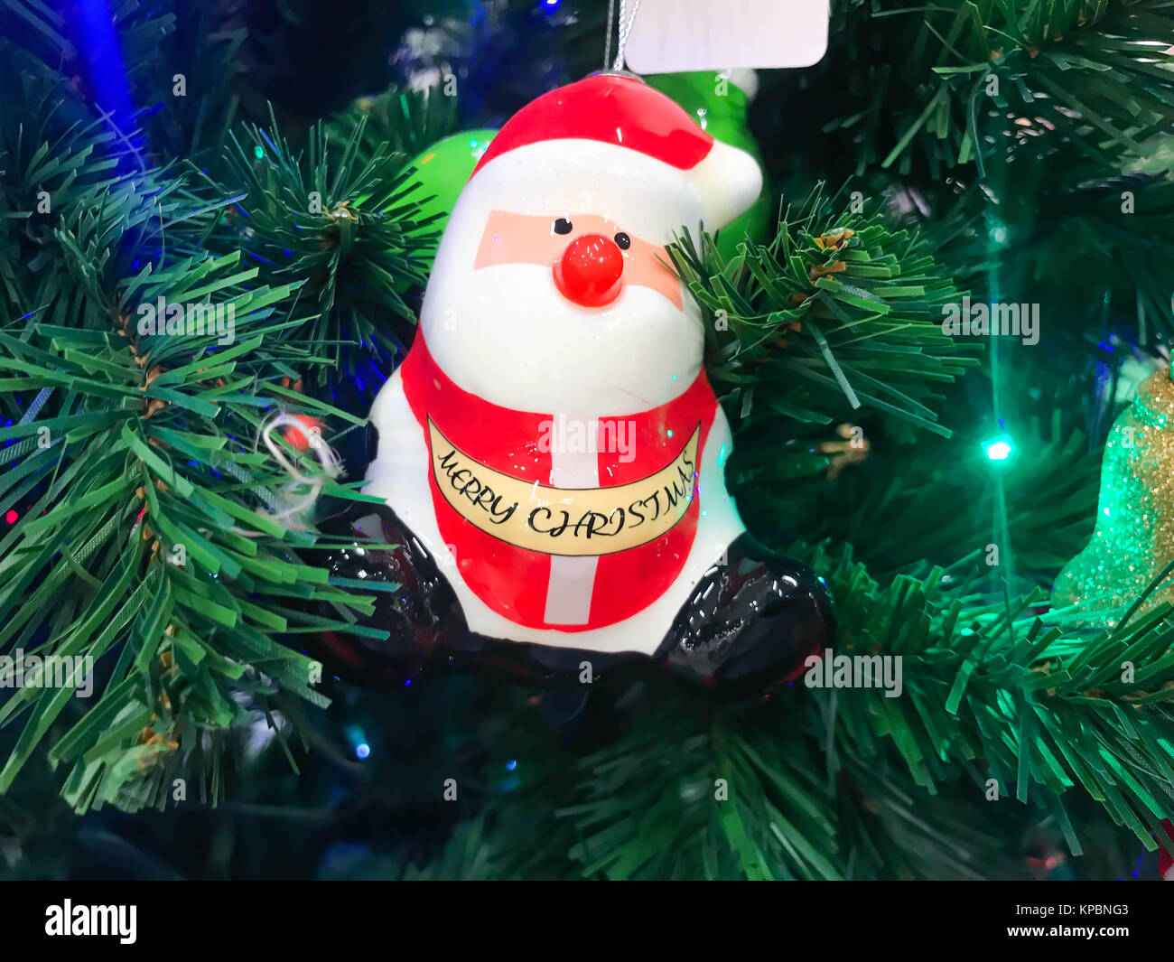 Santa Claus wears a red dress hanging on a Christmas tree Stock Photo ...