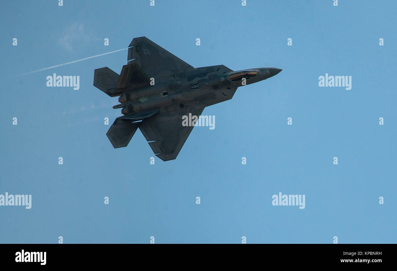 A U.S. Air Force F-22 Raptor stealth tactical fighter aircraft flies over the Joint Base Andrews during an air show rehearsal September 18, 2015 near Clinton, Maryland. Stock Photo