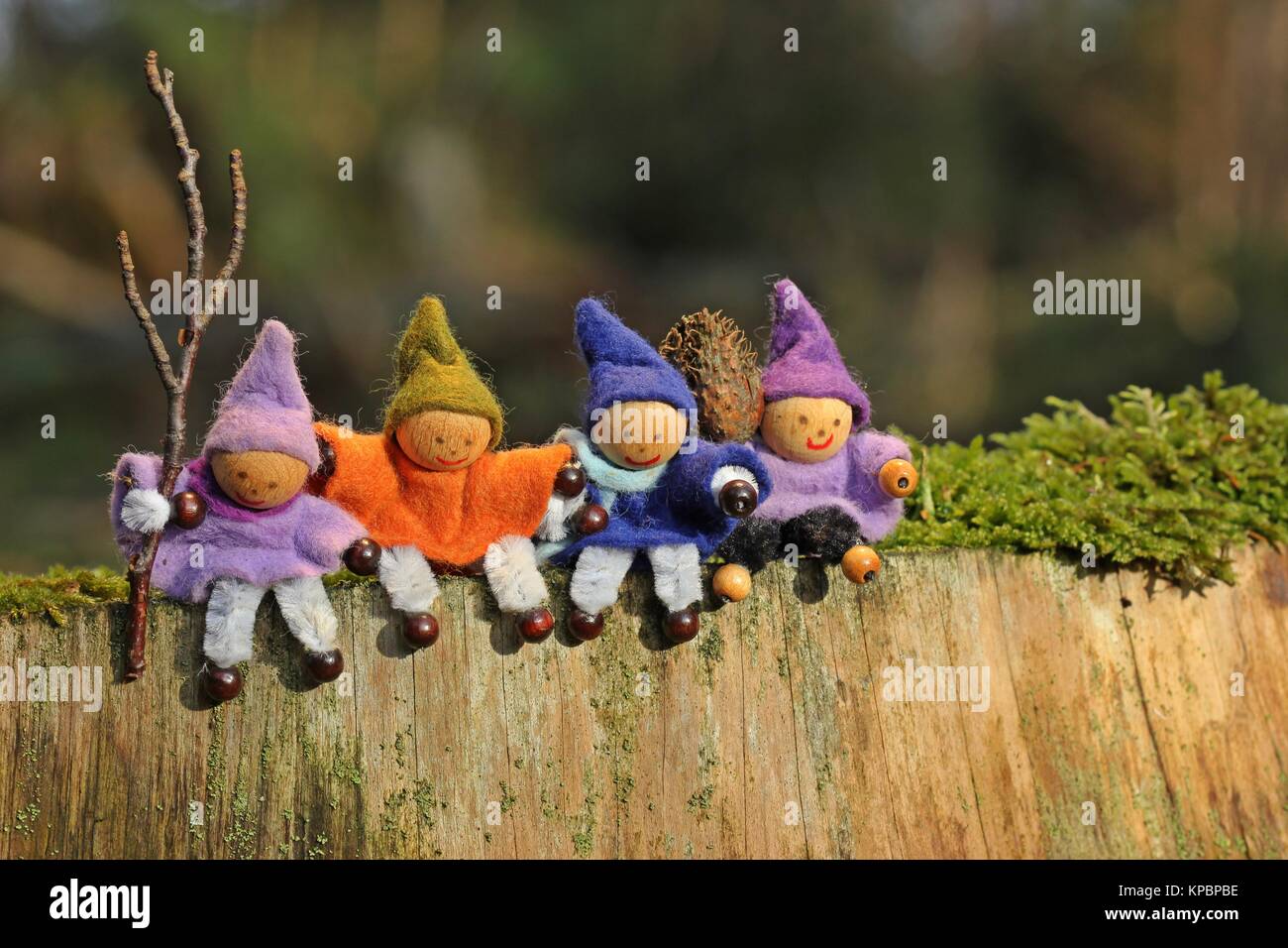Four little gnomes sit on a tree stump Stock Photo
