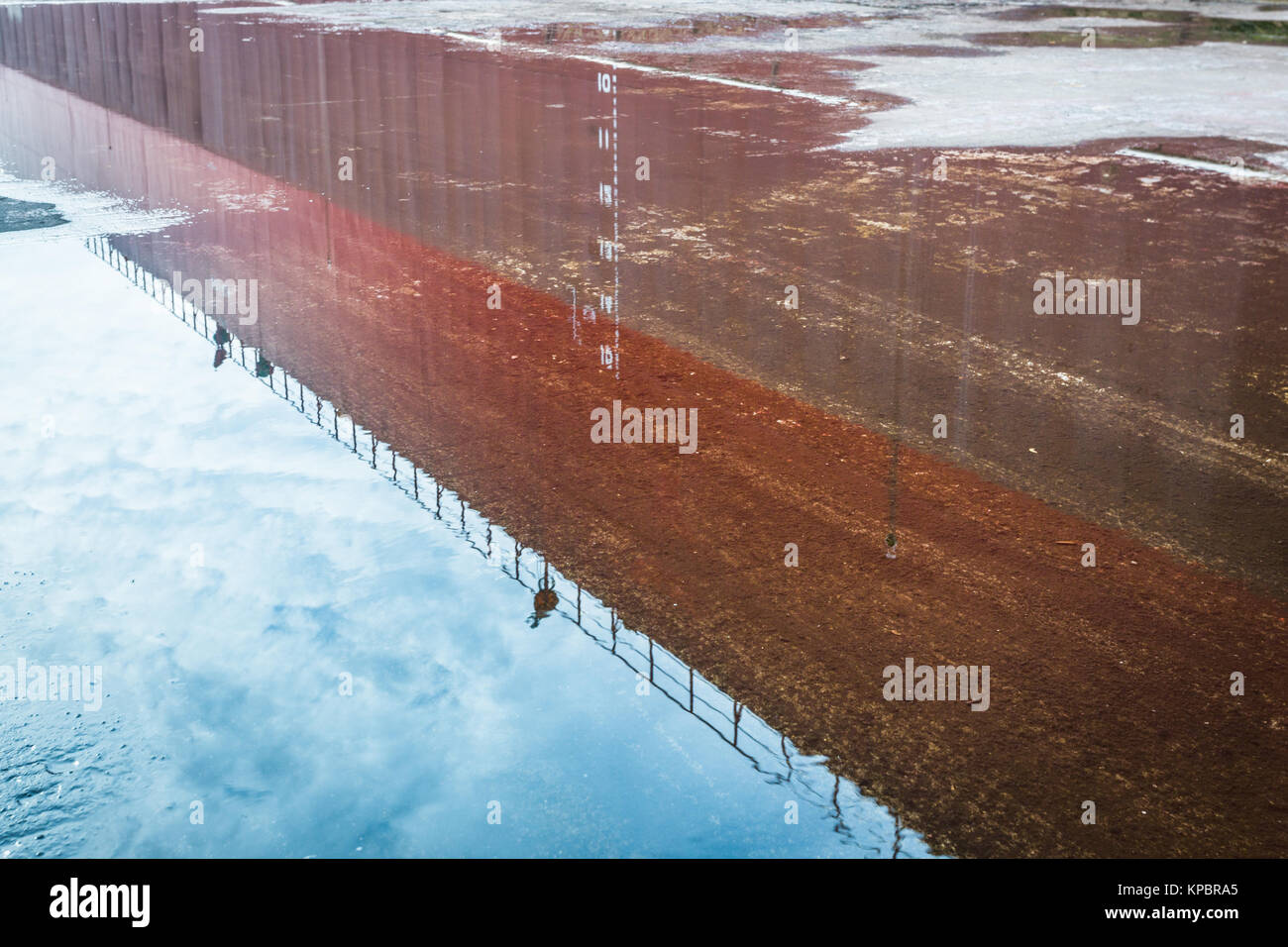 Reflection of building in puddle on street. Stock Photo