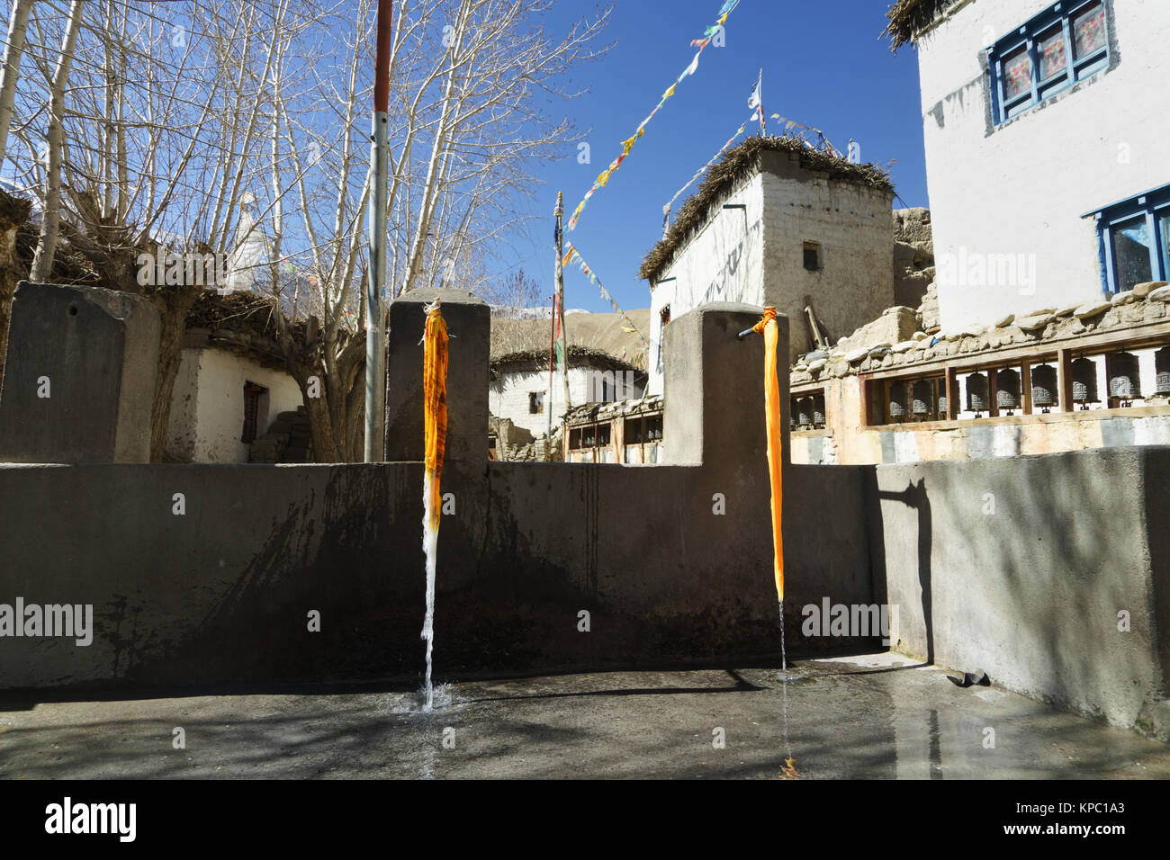 Public water supply adjacent to a Mani wall in the Tibetan village of Ghemi, Upper Mustang region, Nepal. Stock Photo
