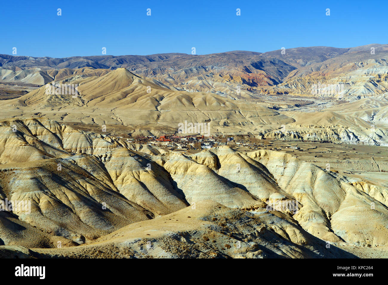 Lo Manthang, capital of Upper Mustang, viewed from a distance amidst a barren desertic landscape. Stock Photo