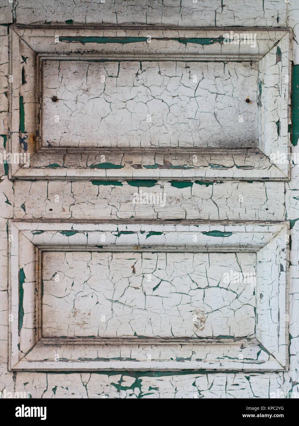 Close up of two panels of old door with cracked and peeling white paint Stock Photo