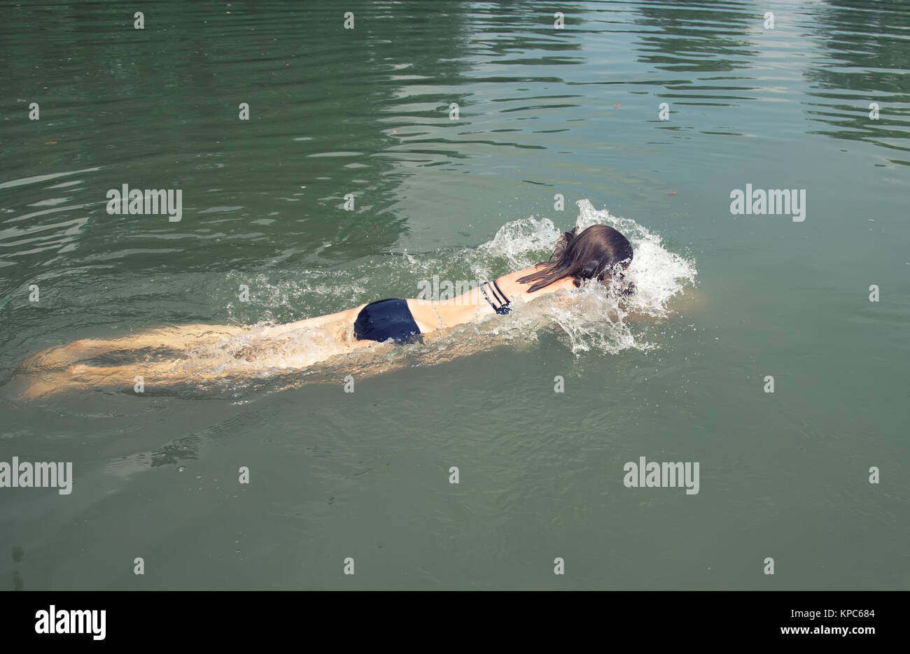 young woman splashing water while swimming Stock Photo Alamy