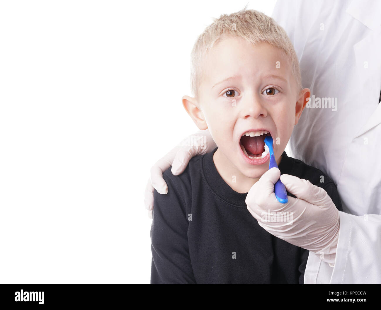 Boy gets help by the Dentist to brush his teeth Stock Photo