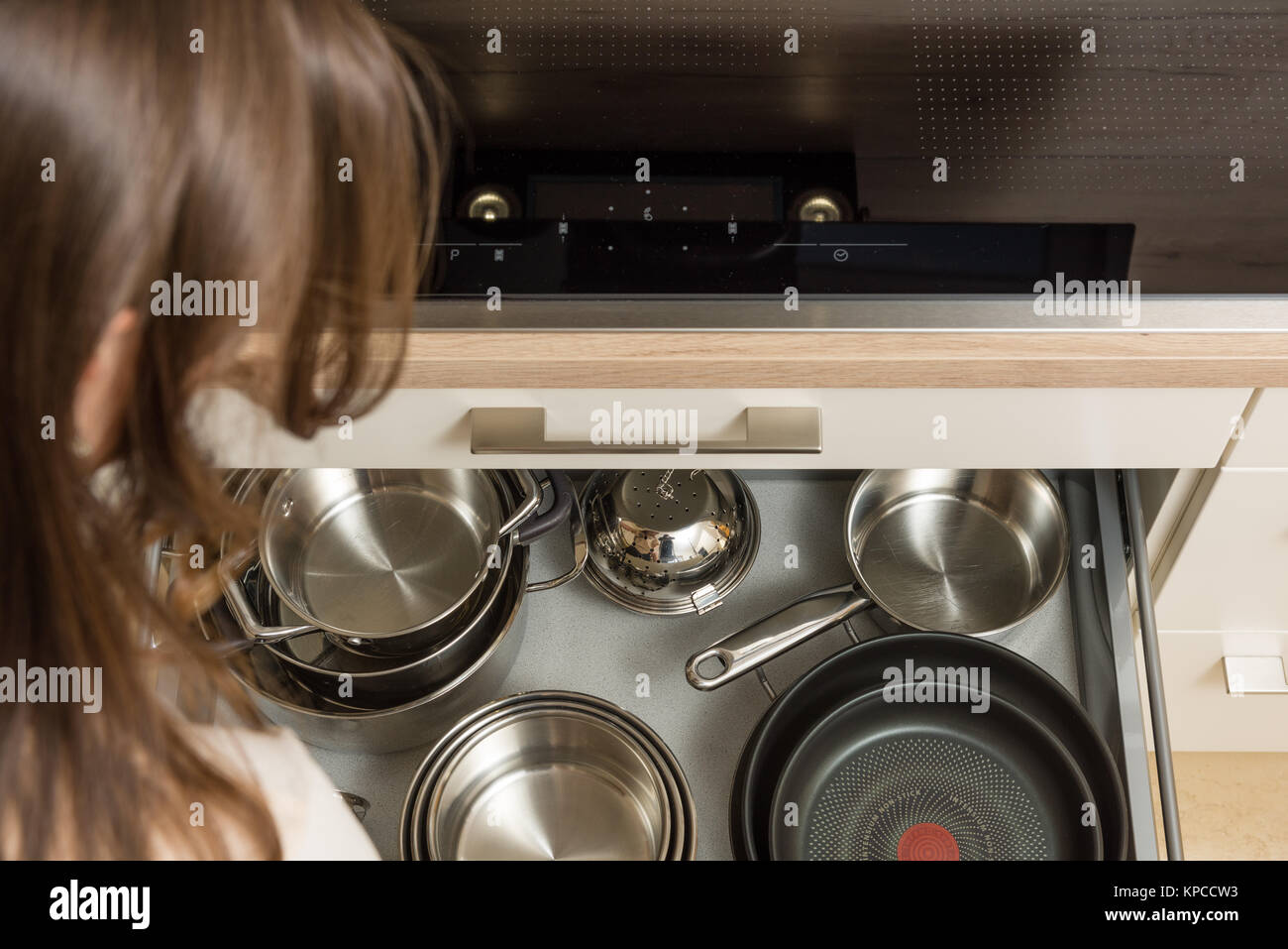 Top down view on modern ceramic cooker with open drawer under the stove