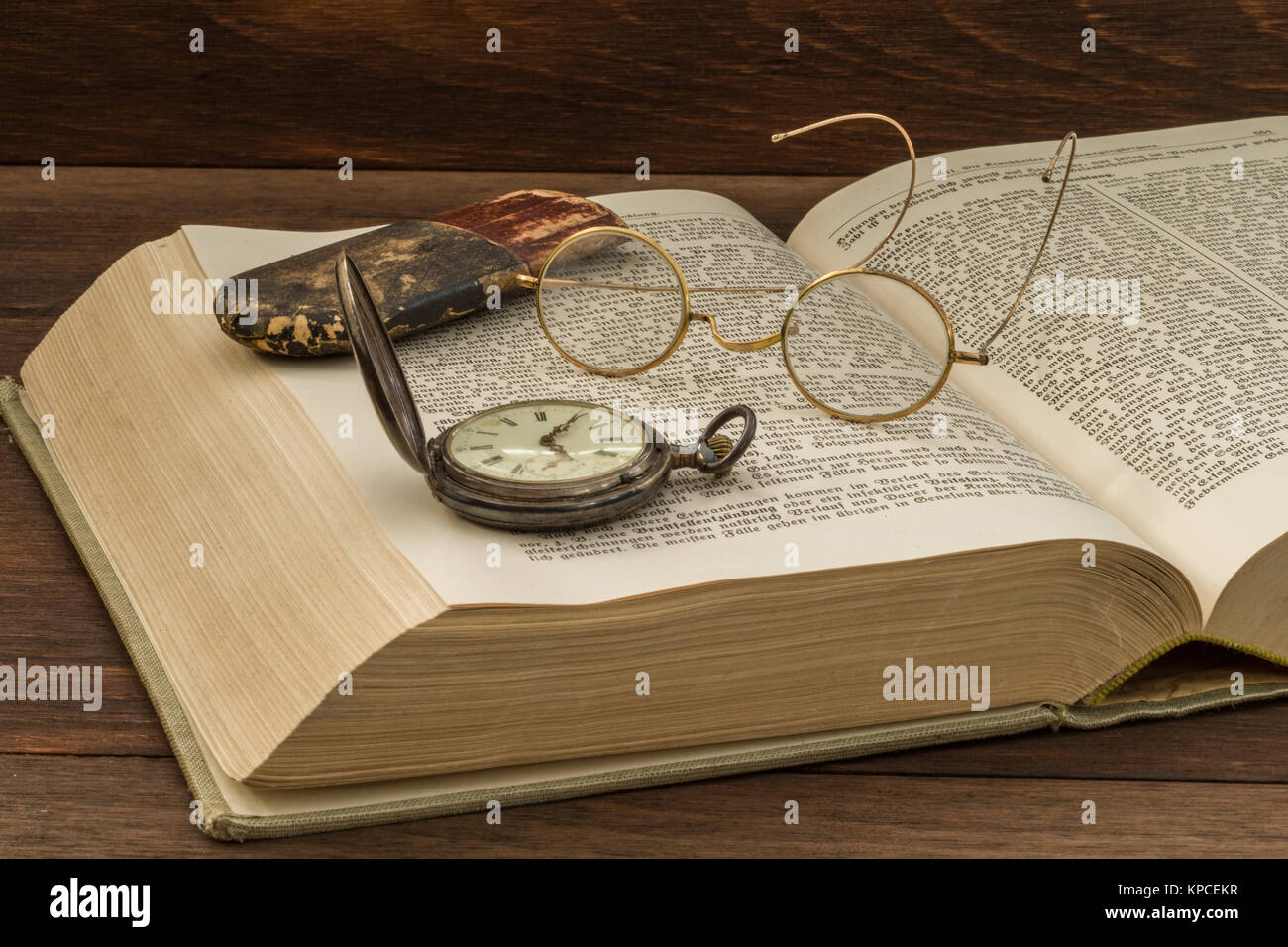 old book with glasses and pocket watch Stock Photo