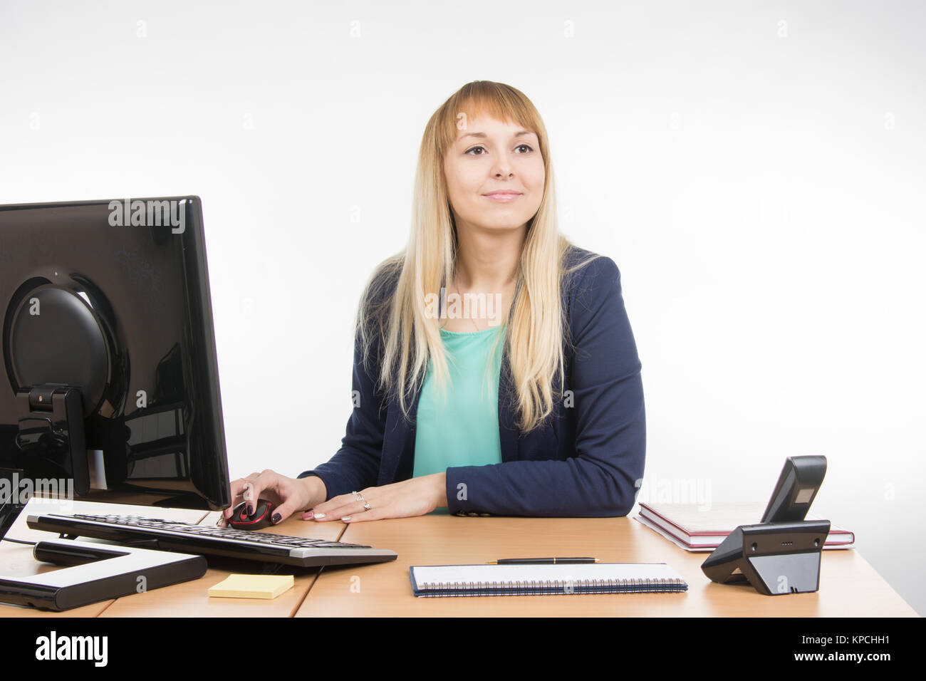 Beautiful girl secretary working at a computer looked at visitor Stock ...