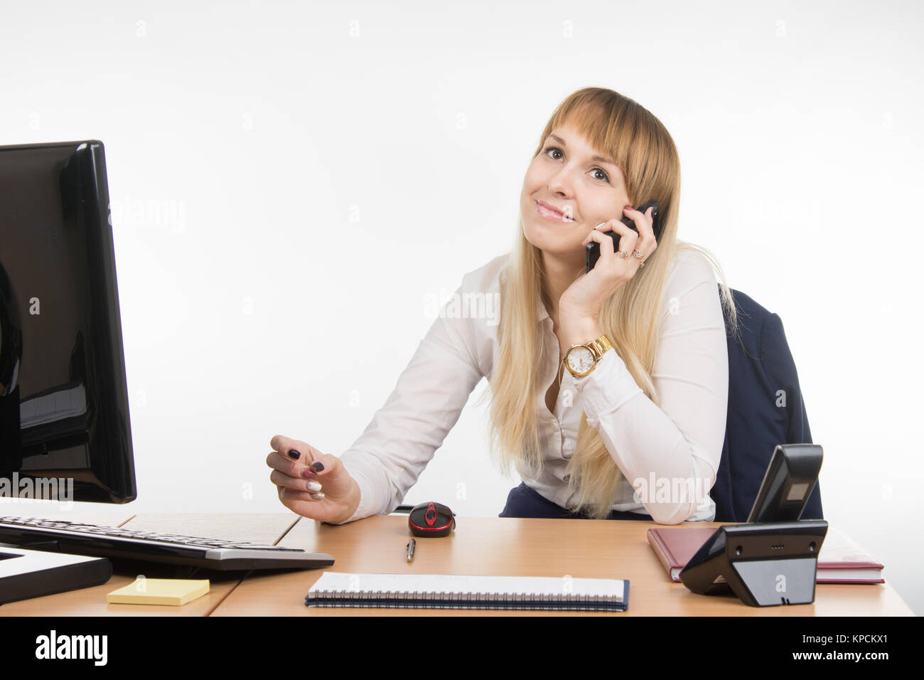 Office Specialist talking on a cell phone in the workplace Stock Photo