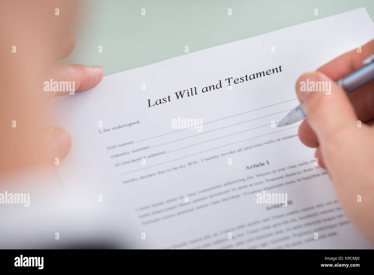 Person Hand Over Last Will And Testament Form Stock Photo