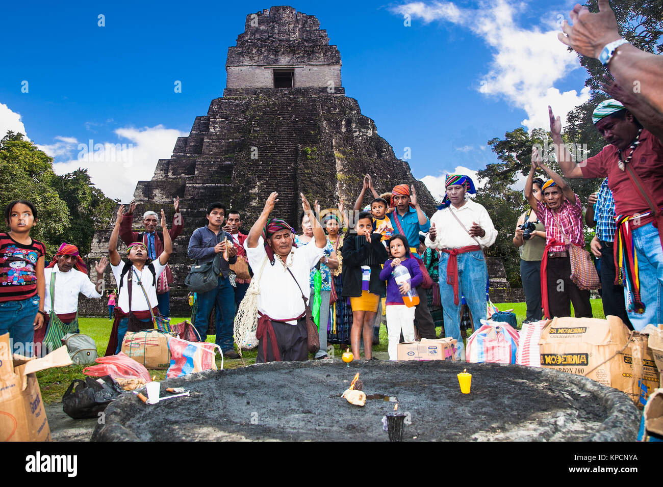 TIKAL, GUATEMALA - DEC 21, 2015: Unidentified Mayan people and tourists surround a fire on December 21, 2015  in Tikal, Guatemala. Traditional Mayan f Stock Photo