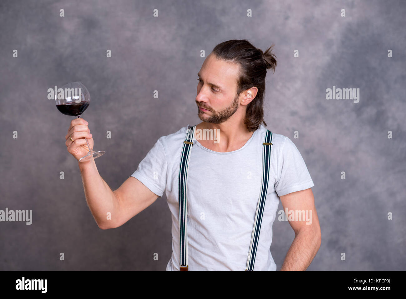 young man in front of gray background drinking red wine Stock Photo - Alamy