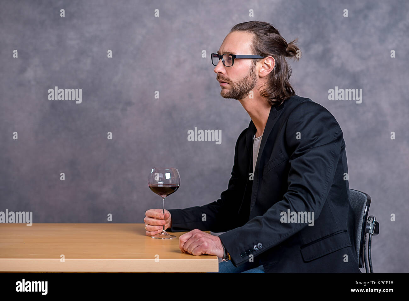 young man sitting at the table and drinking red wine Stock Photo - Alamy