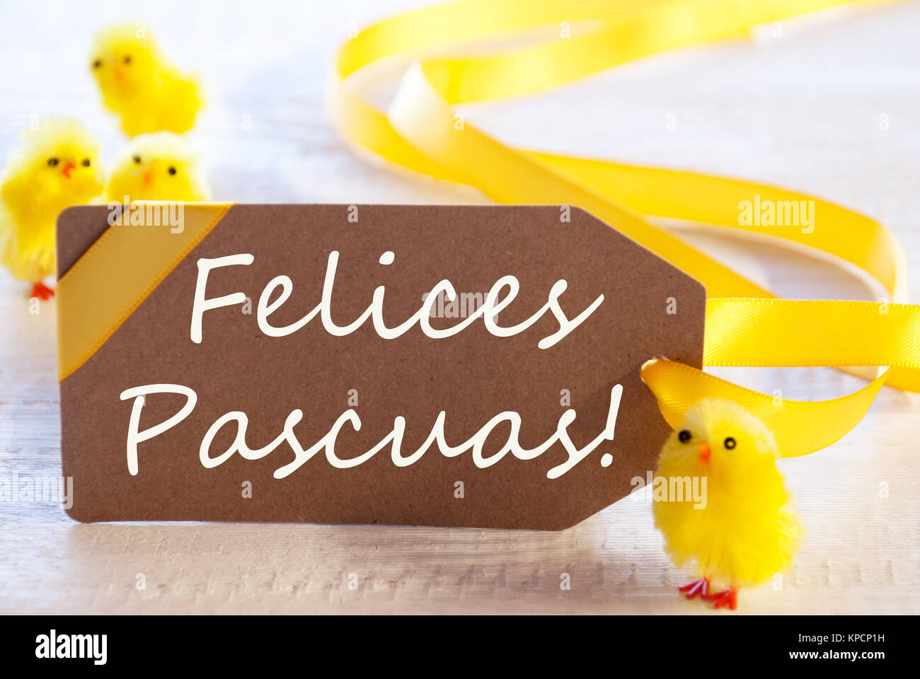 One Brown Label With Yellow Ribbon. Spanish Text Felices Pascuas Means Happy Easter. Card For Easter Greetings On Wooden Background Stock Photo