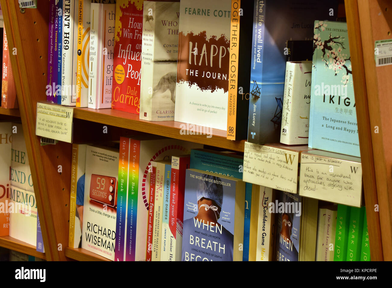 a selection of self help books for sale on shelves at a major high street book and gift retailer. Colourful display of books and literature on shelves Stock Photo