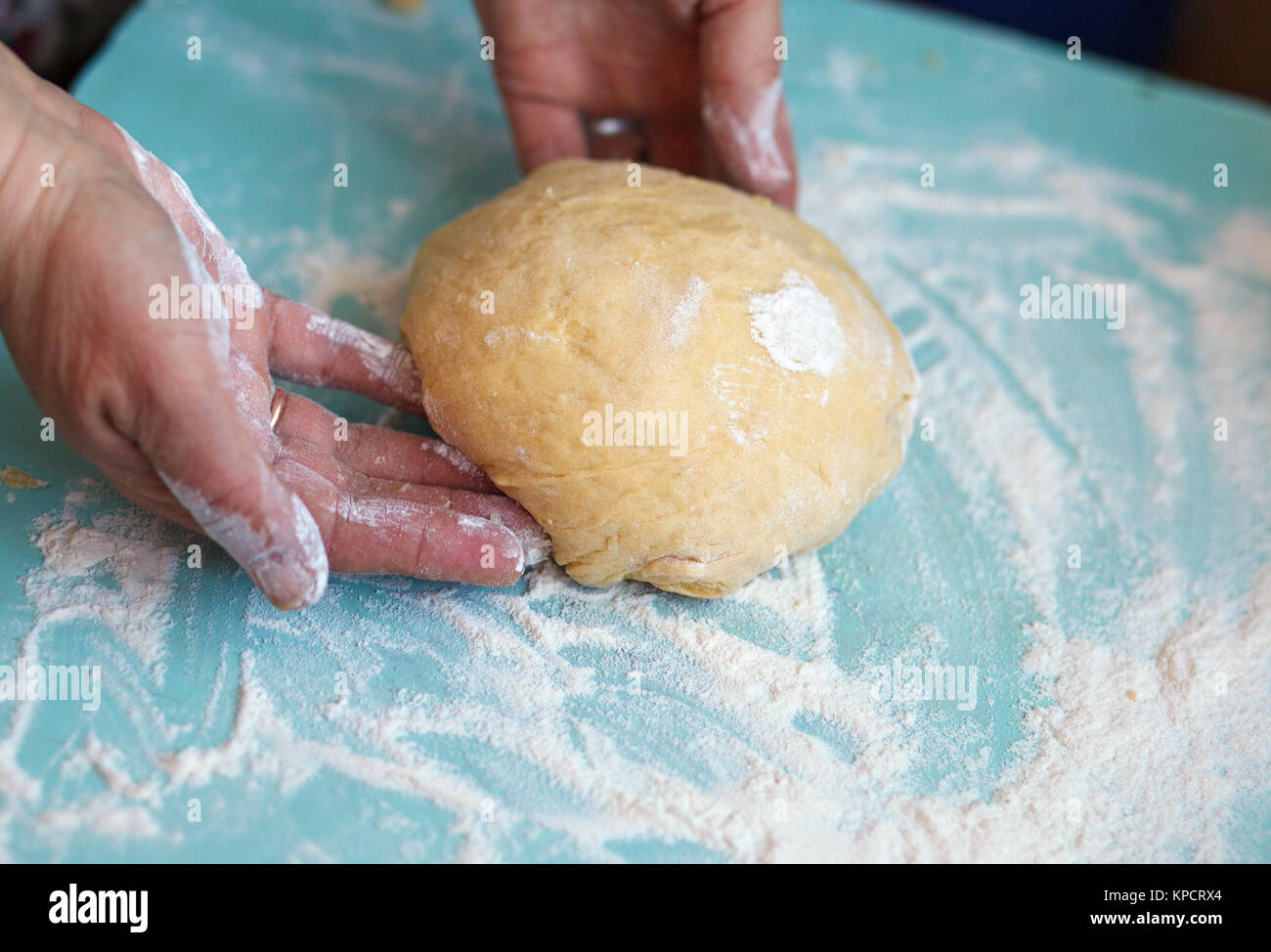 Woman's hands knead dough on a table Stock Photo - Alamy